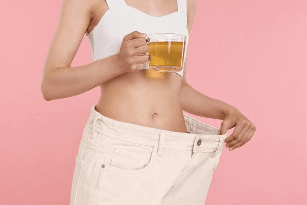 Friska Herbal teas weight loss concept woman with cup diet tea big pants pink background closeup 495423 96626